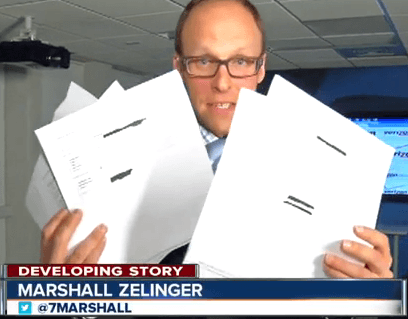 KMGH Denver reporter Marshall Zelweger holds up some of the emails received in the newsroom from victims that had new iPhone 6 smartphones billed to their account. (Image: KMGH-TV/Denver)