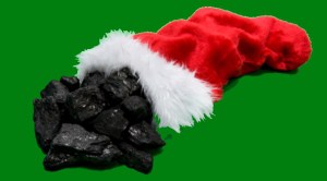 Christmas Stocking with chunks of coal laying on a green textured background